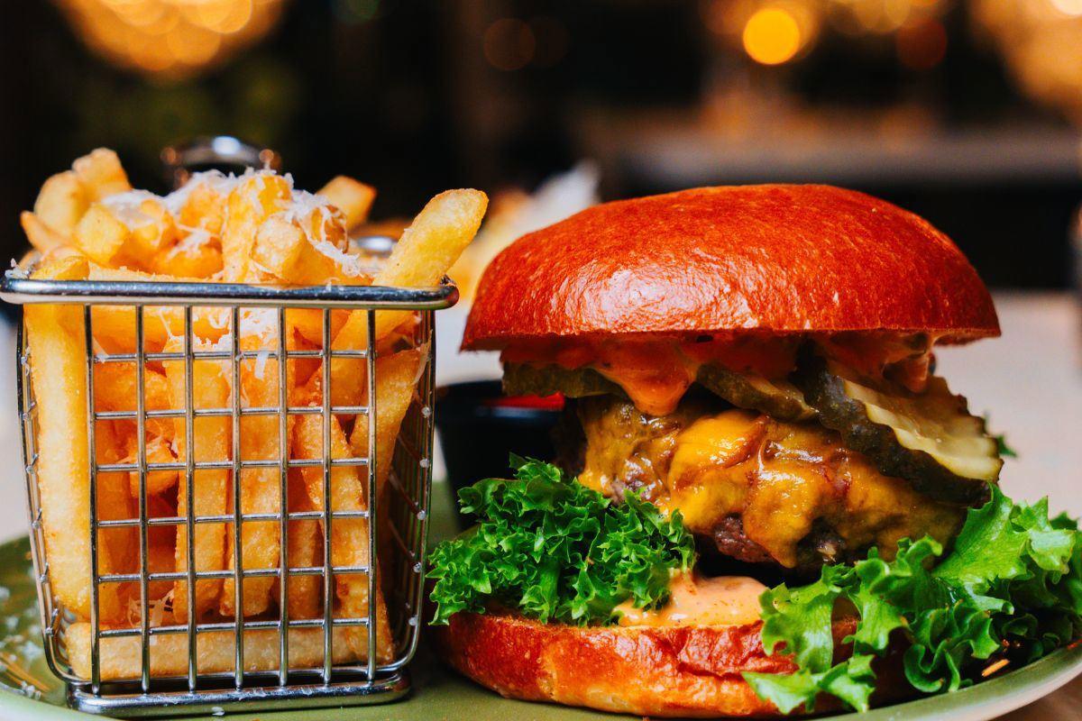 A burger with fresh vegetables and French fries, served at The Social Bar & Bistro.
