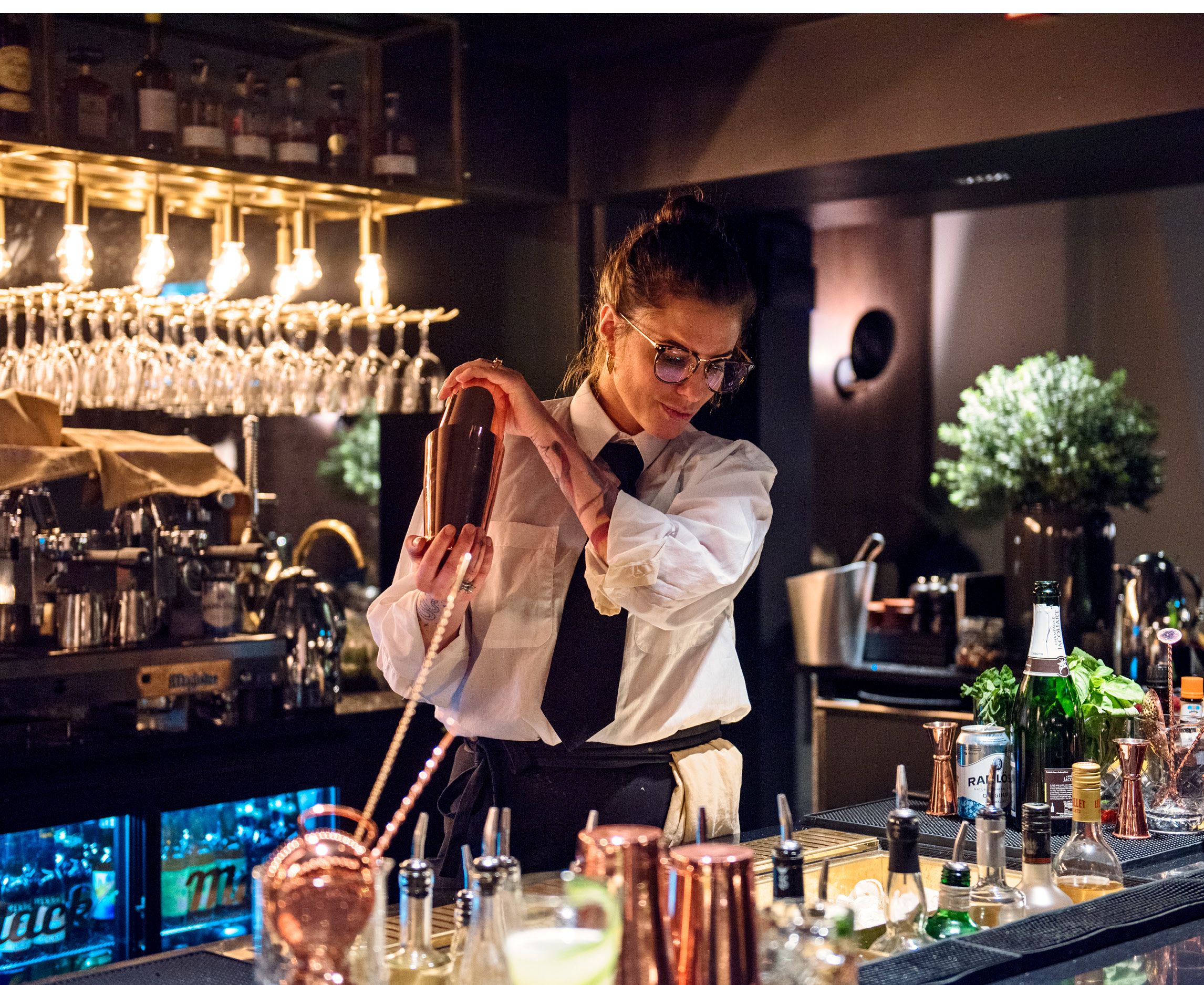 A bartender mixing a drink behind a bar