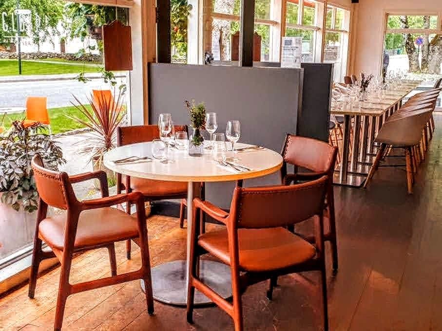 Bright and modern interior at Gløyp Spiseri, featuring large windows with natural light and comfortable seating.