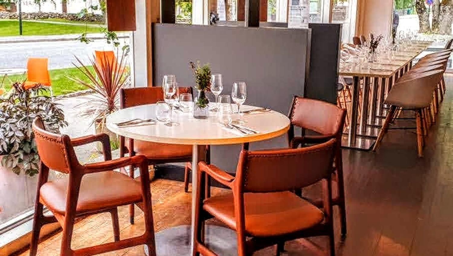 Bright and modern interior at Gløyp Spiseri, featuring large windows with natural light and comfortable seating.
