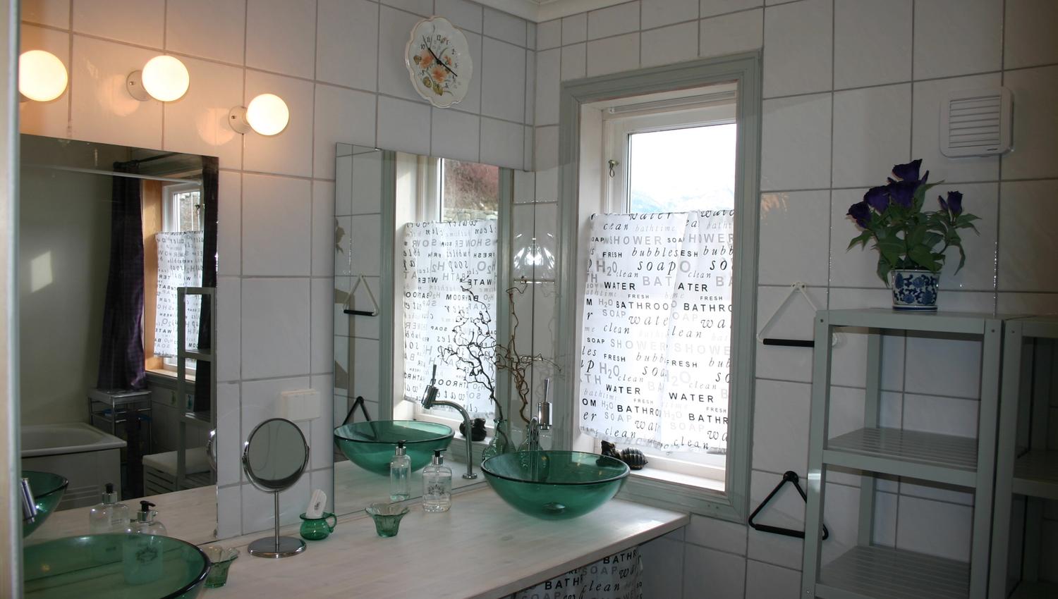 Bright bathroom with twin green glass sinks at Hardanger Harmoni Fjordhus.