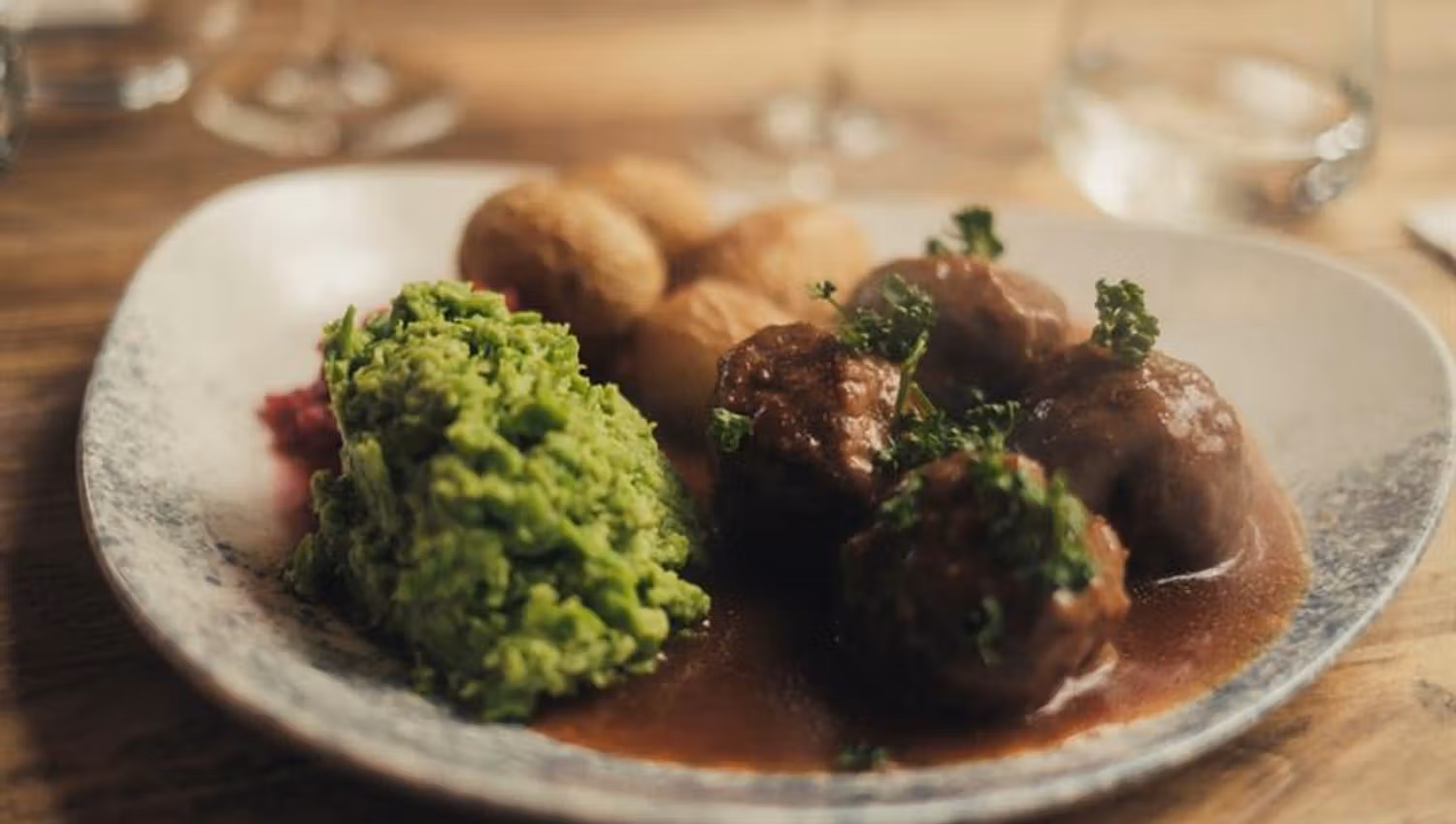 Detalj av kjøttkaker, ertestuing og poteter i brun saus