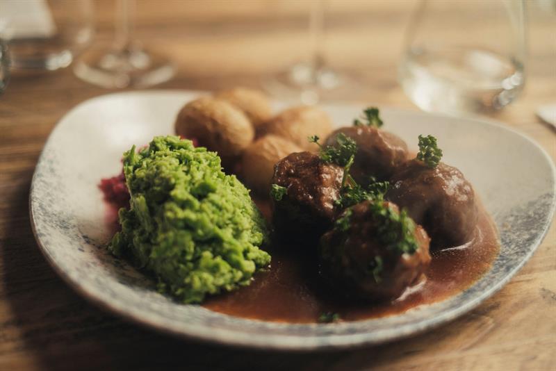 Detalj av kjøttkaker, ertestuing og poteter i brun saus