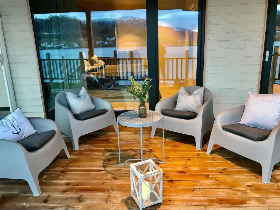 Cozy outdoor space with modern furniture and fjord views – perfect for relaxation.