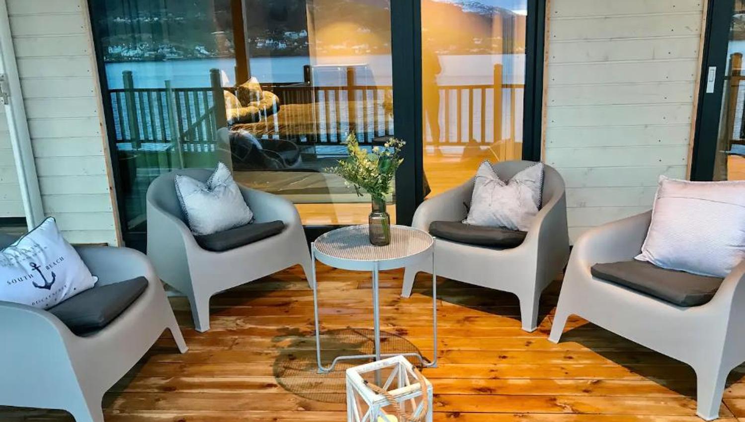 Cozy outdoor space with modern furniture and fjord views – perfect for relaxation.