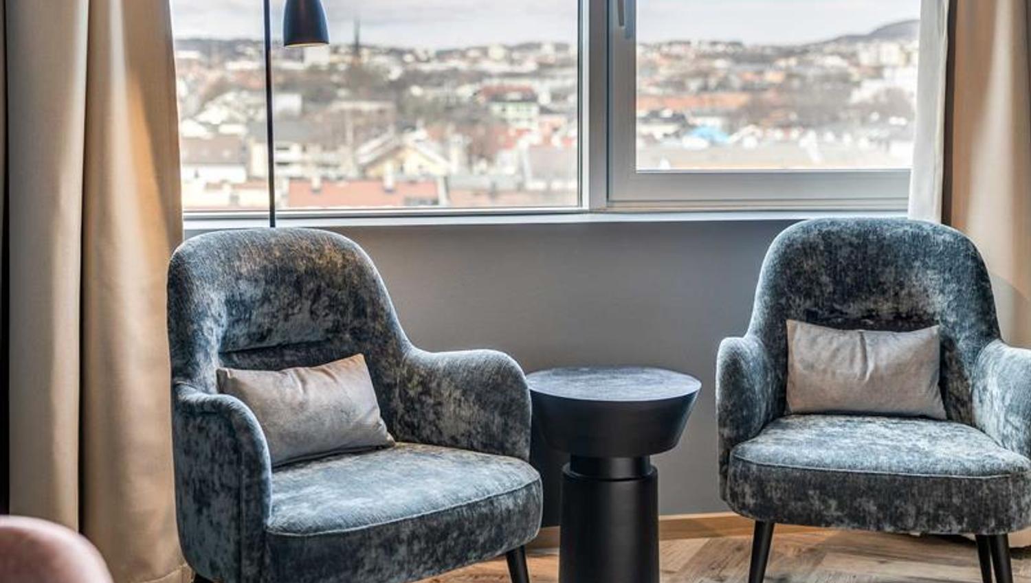 Detalj av to blå lenestoler foran vindu med utsikt over nordøstlige Oslo