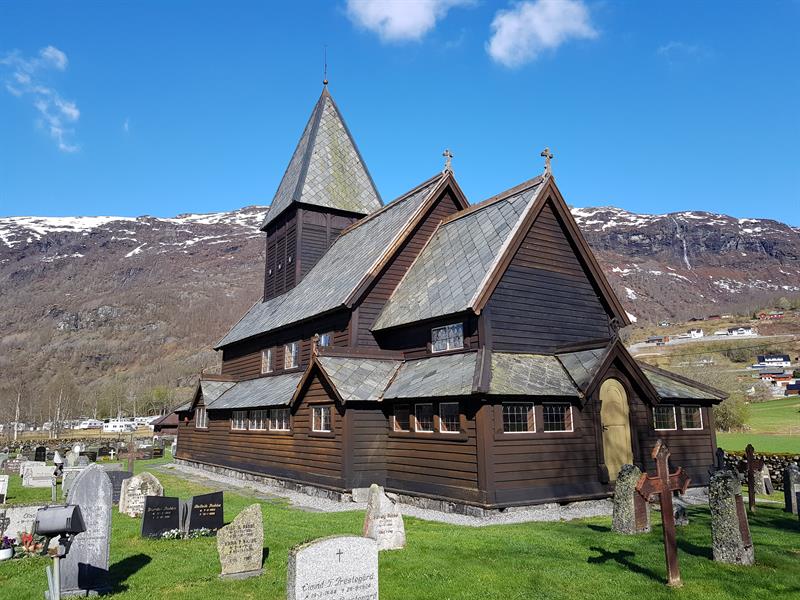 Røldal Stave Church with a view of the Hardanger mountains, a peaceful place rich in history.