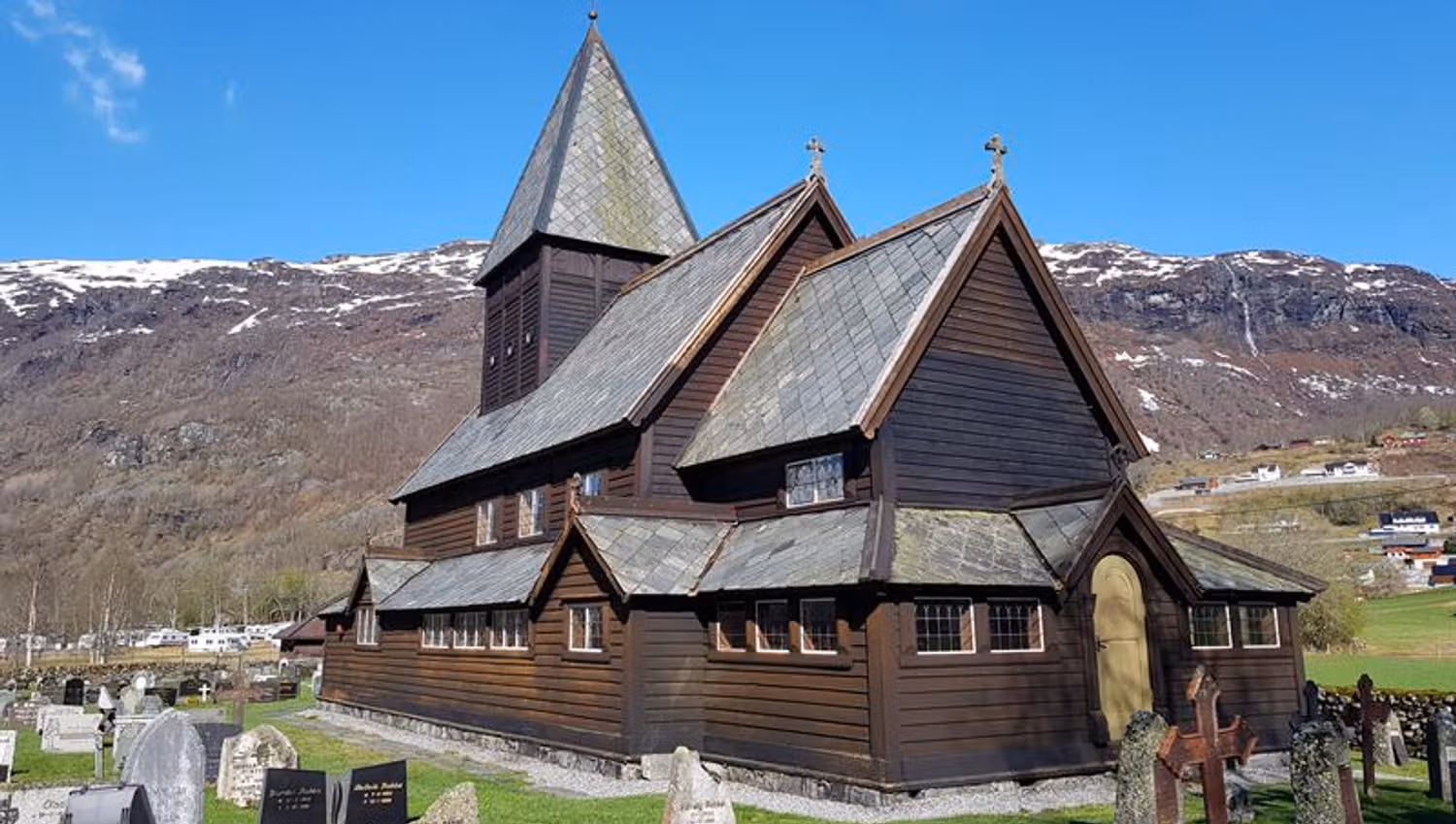 Røldal Stave Church with a view of the Hardanger mountains, a peaceful place rich in history.