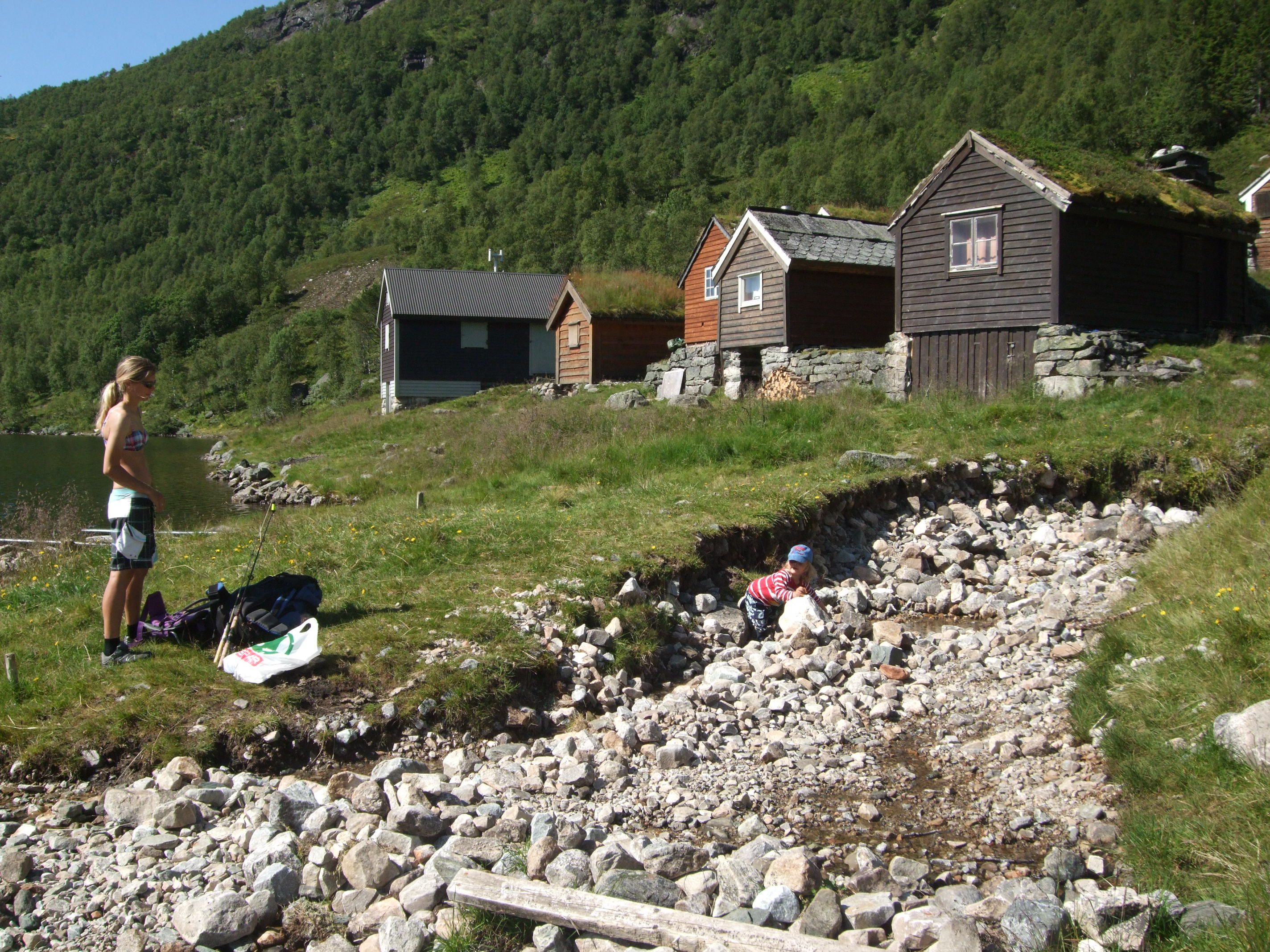 a woman is out hiking by the lake and the mountain farm 