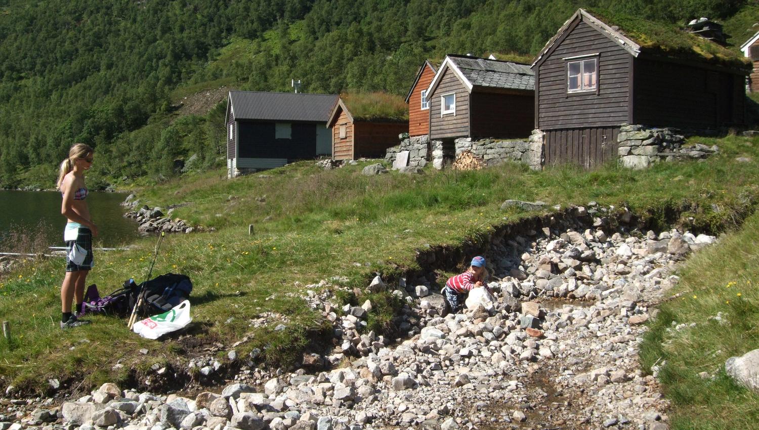 a woman is out hiking by the lake and the mountain farm