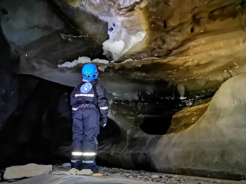 A child looking at ice formations inside the ice cave