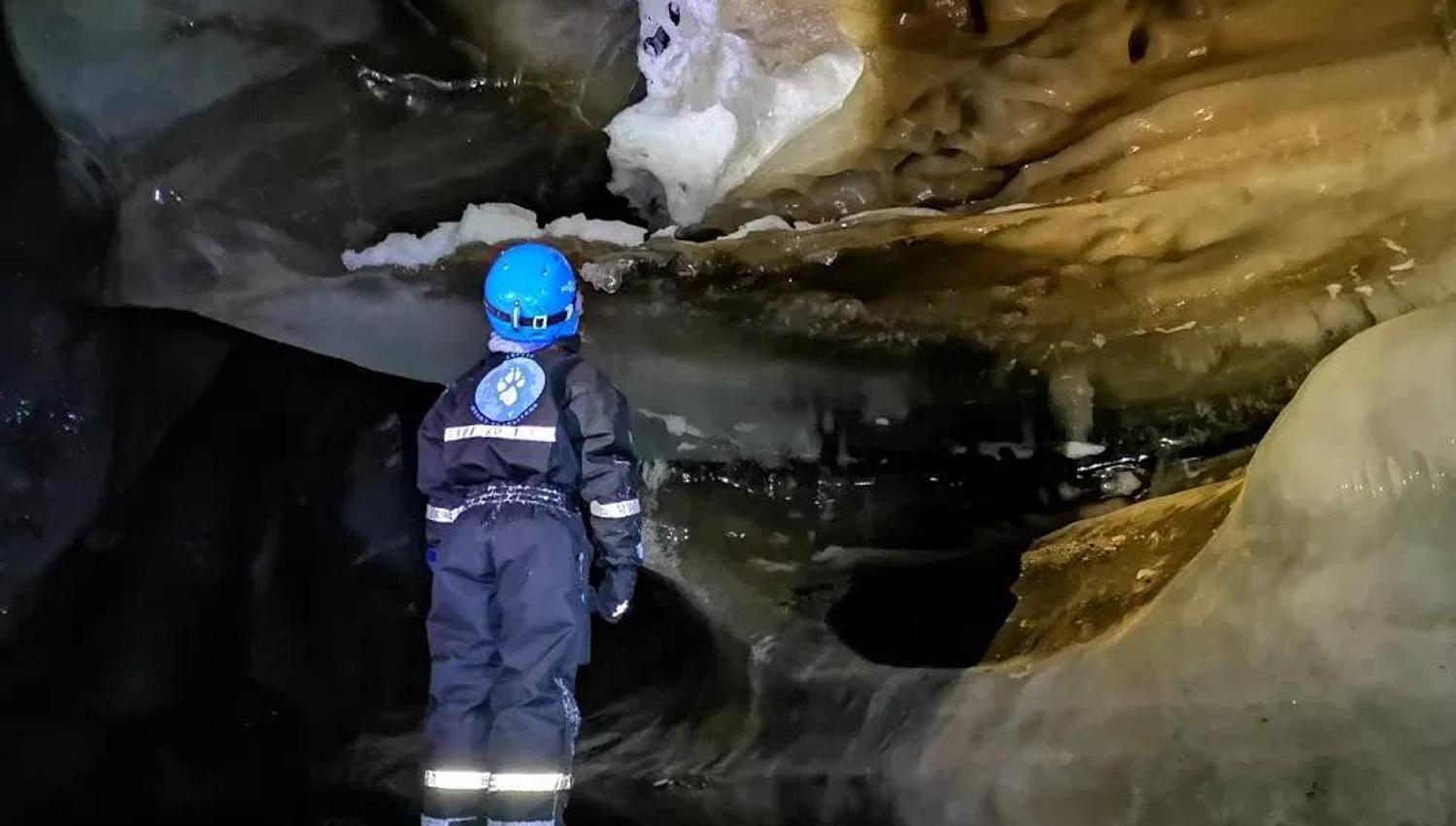 A child looking at ice formations inside the ice cave
