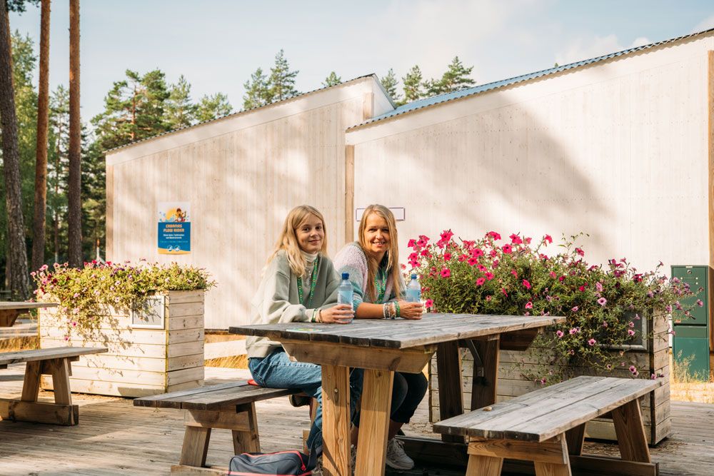 2 girls sitting on a picnic bench in one of the quiet areas in Bø Sommarland 