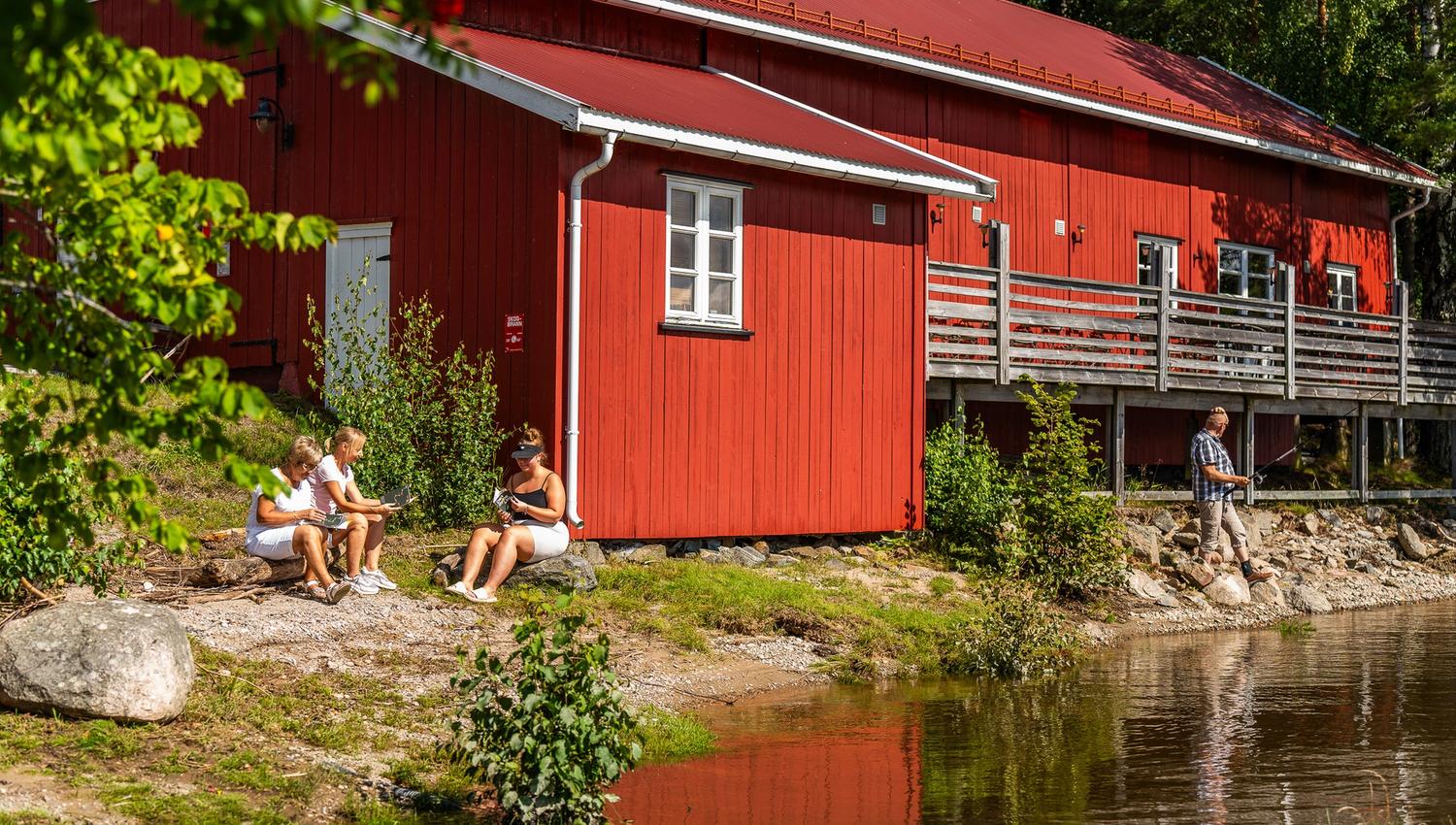 En av bygningene på Sandstangen med folk utenfor som koser seg.