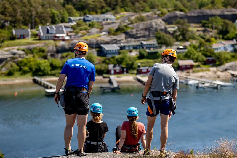 4 personer nyter utsikten mot vannet