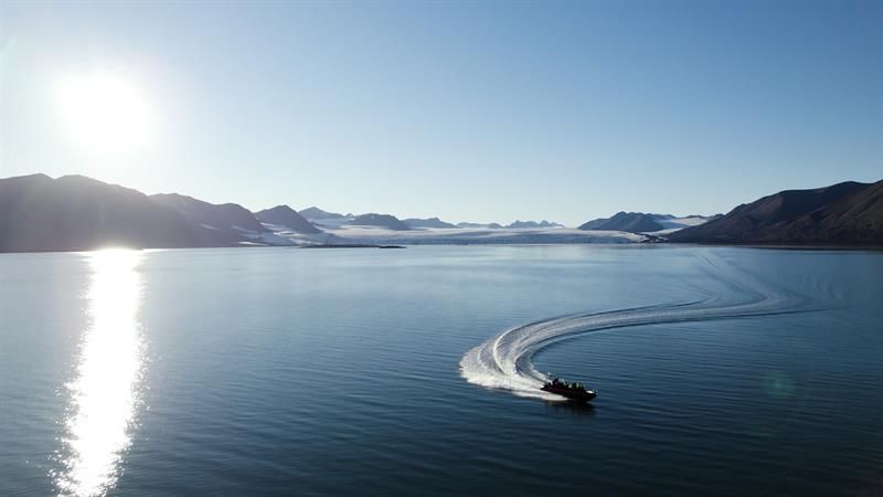 Boat driving on a fjord in sunny weather