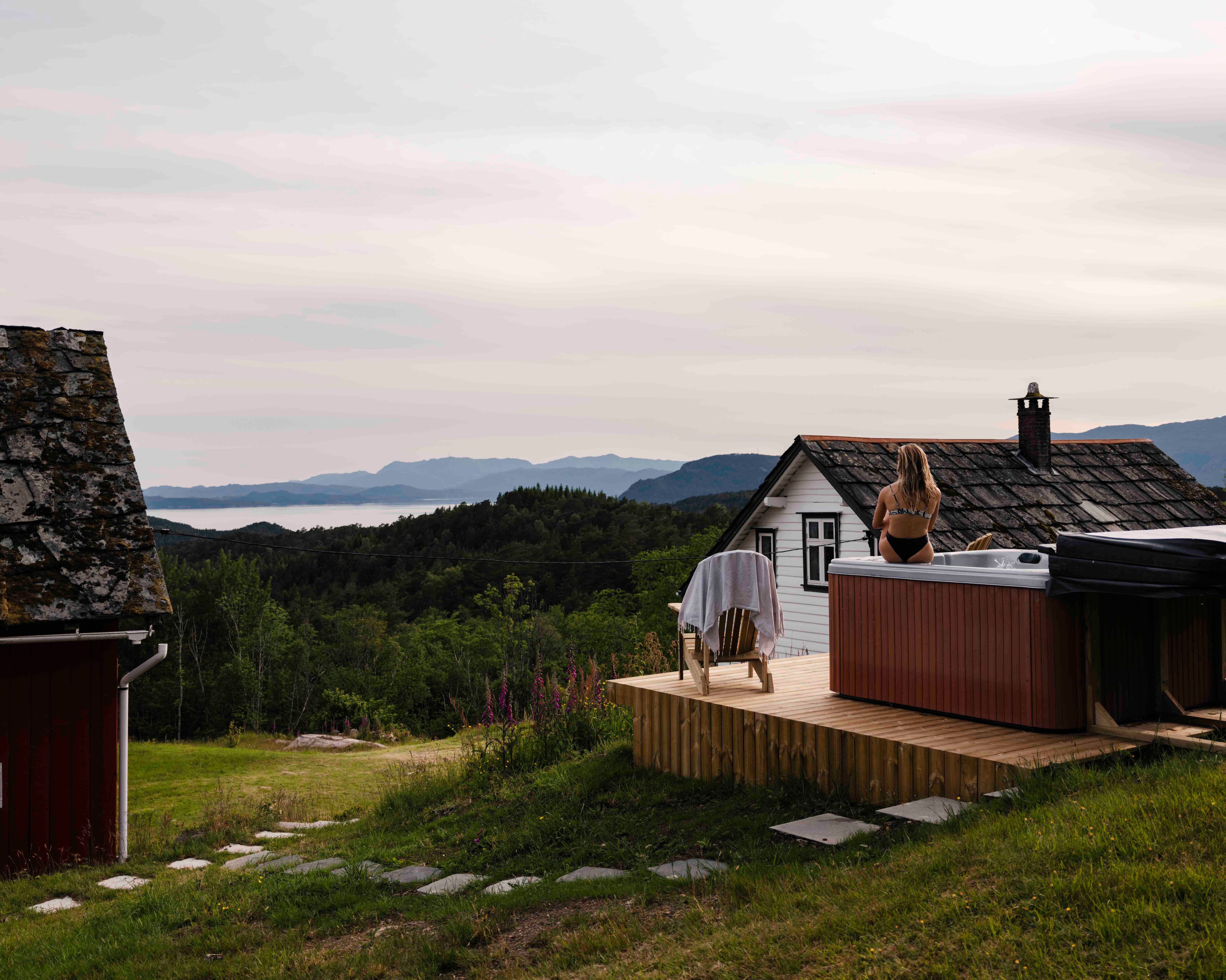 Outdoor hot tub with panoramic fjord and mountain views at Stigen Fjordlodge in Hardanger.
