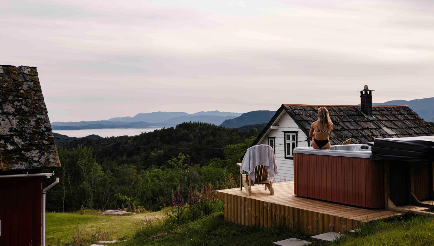 Outdoor hot tub with panoramic fjord and mountain views at Stigen Fjordlodge in Hardanger.
