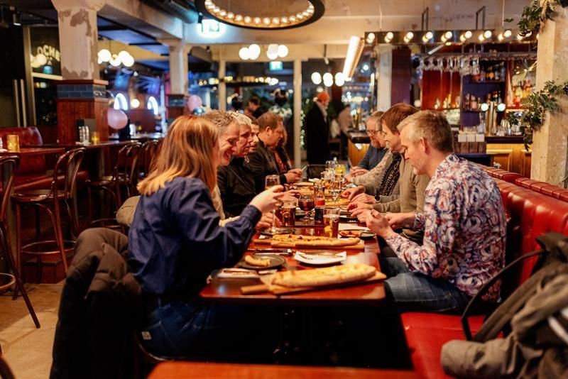 En gruppe personer som spiser ved et langbord