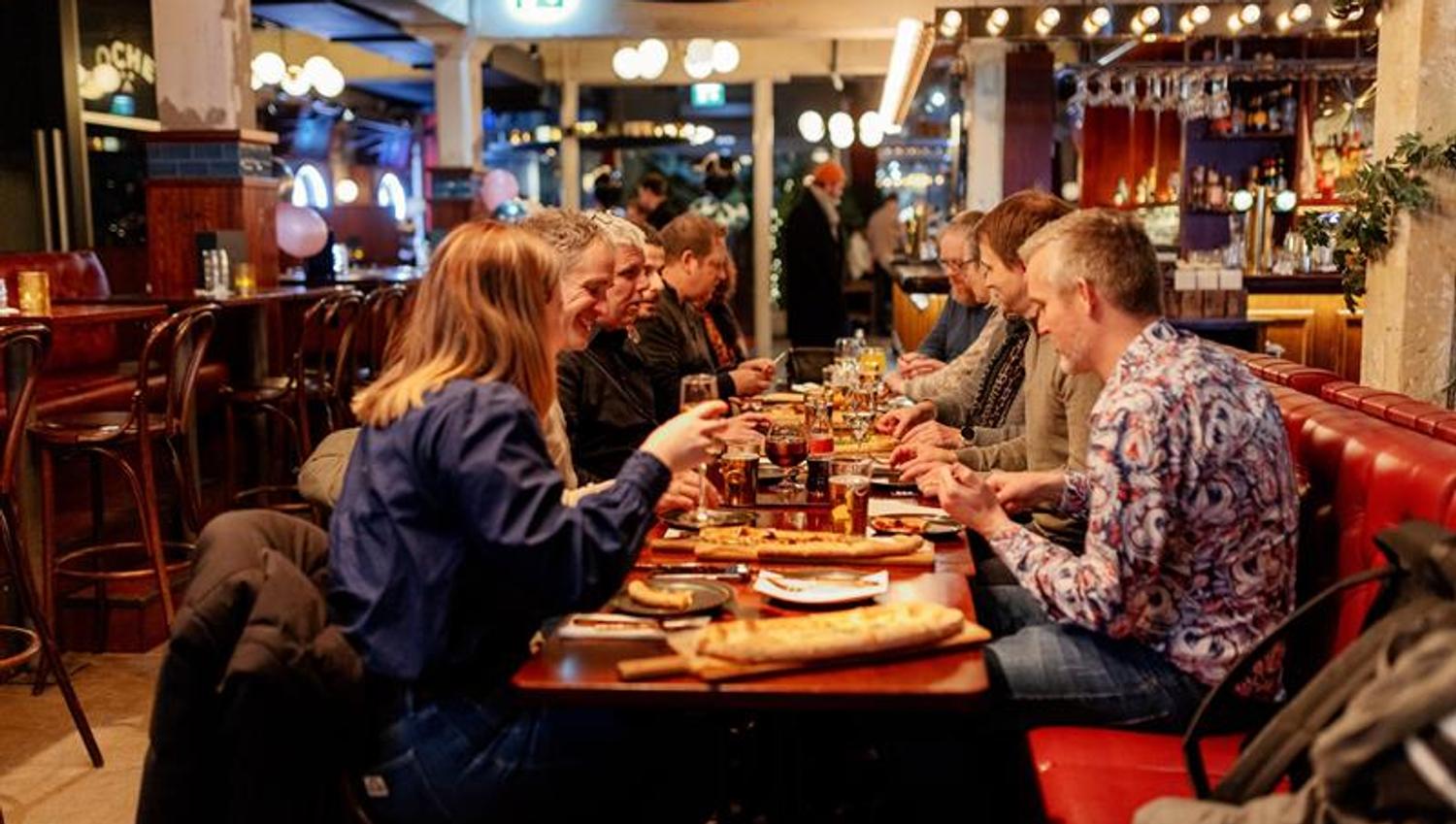 En gruppe personer som spiser ved et langbord