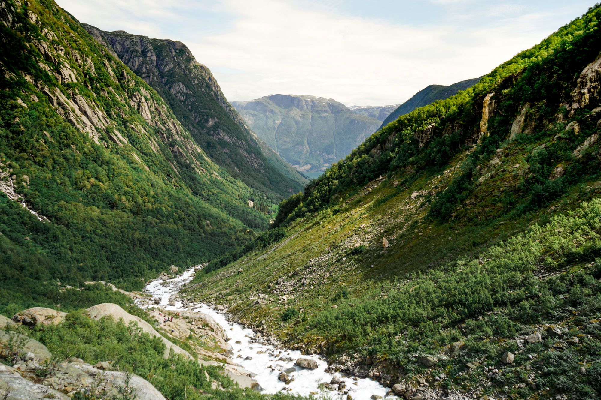 Utsikt ned Buar­dalen med elv, grøne lier og fjell på veg mot Buarbreen.