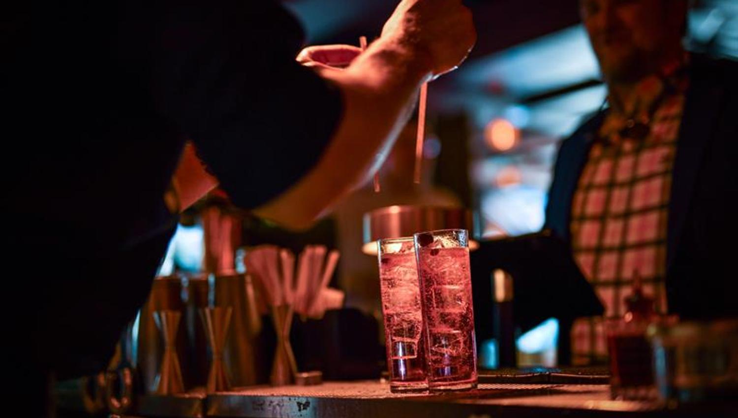 Bartender som putter to sugerør i to drinker