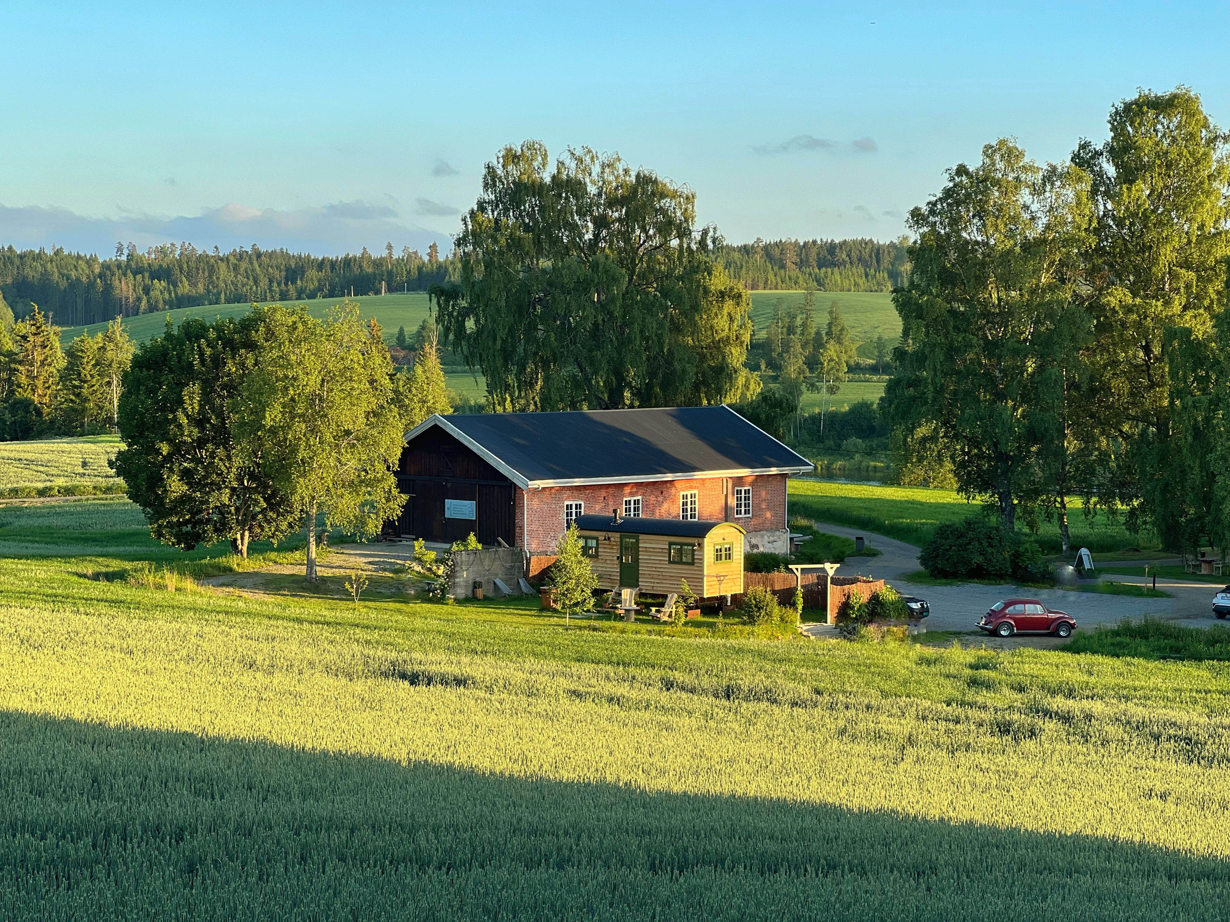 Shepherd´s Hut view fromabove with fields, barn and an old car 