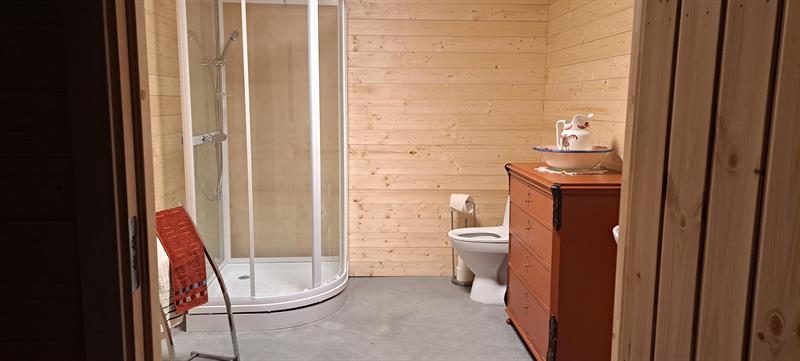 Bathroom with shower, toilet and sink in adjacent building next to Gjeterhytta