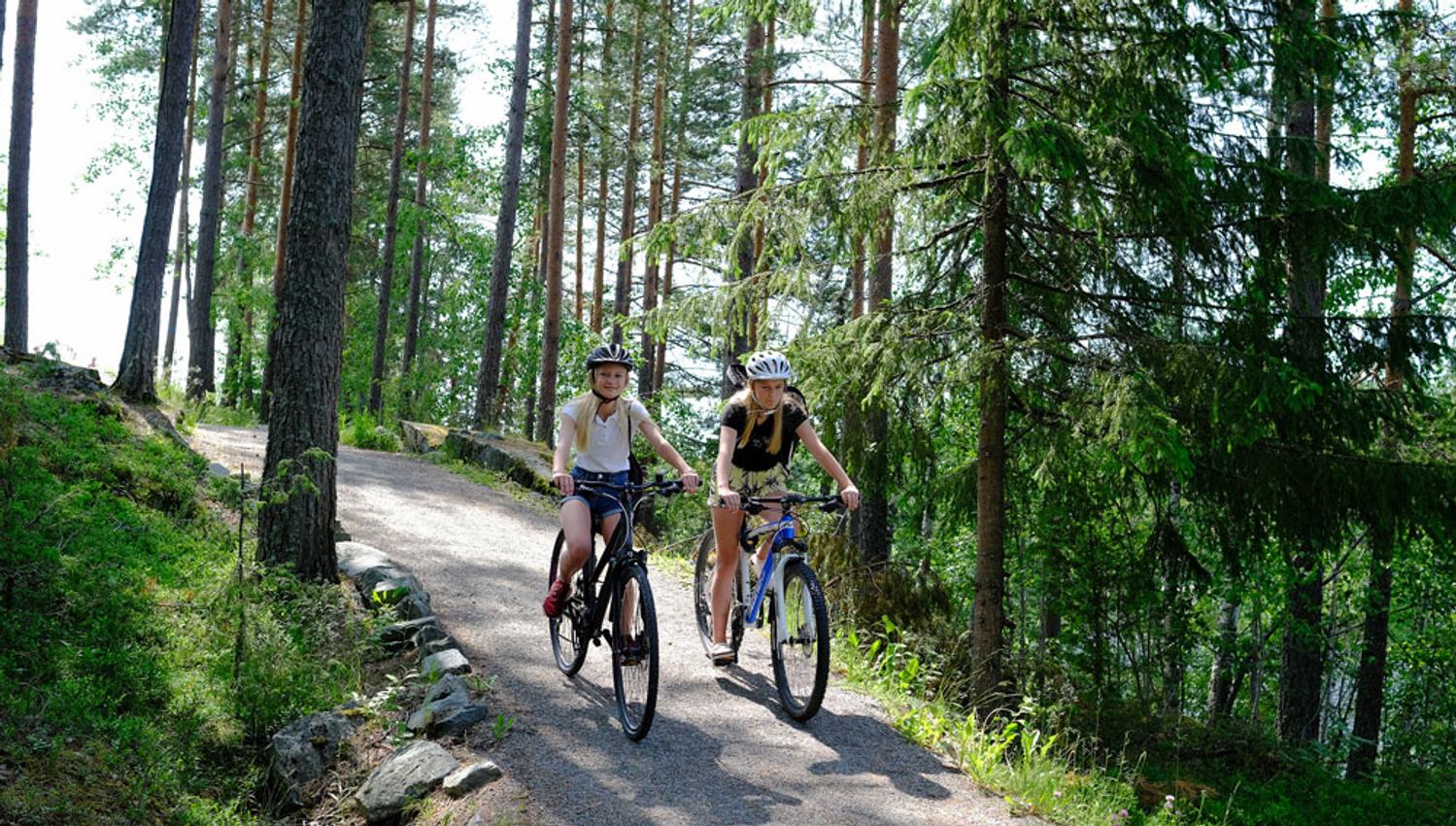 To jenter på hver sin sykkel langs veien rundt Tinnemyra, Notodden. Foto