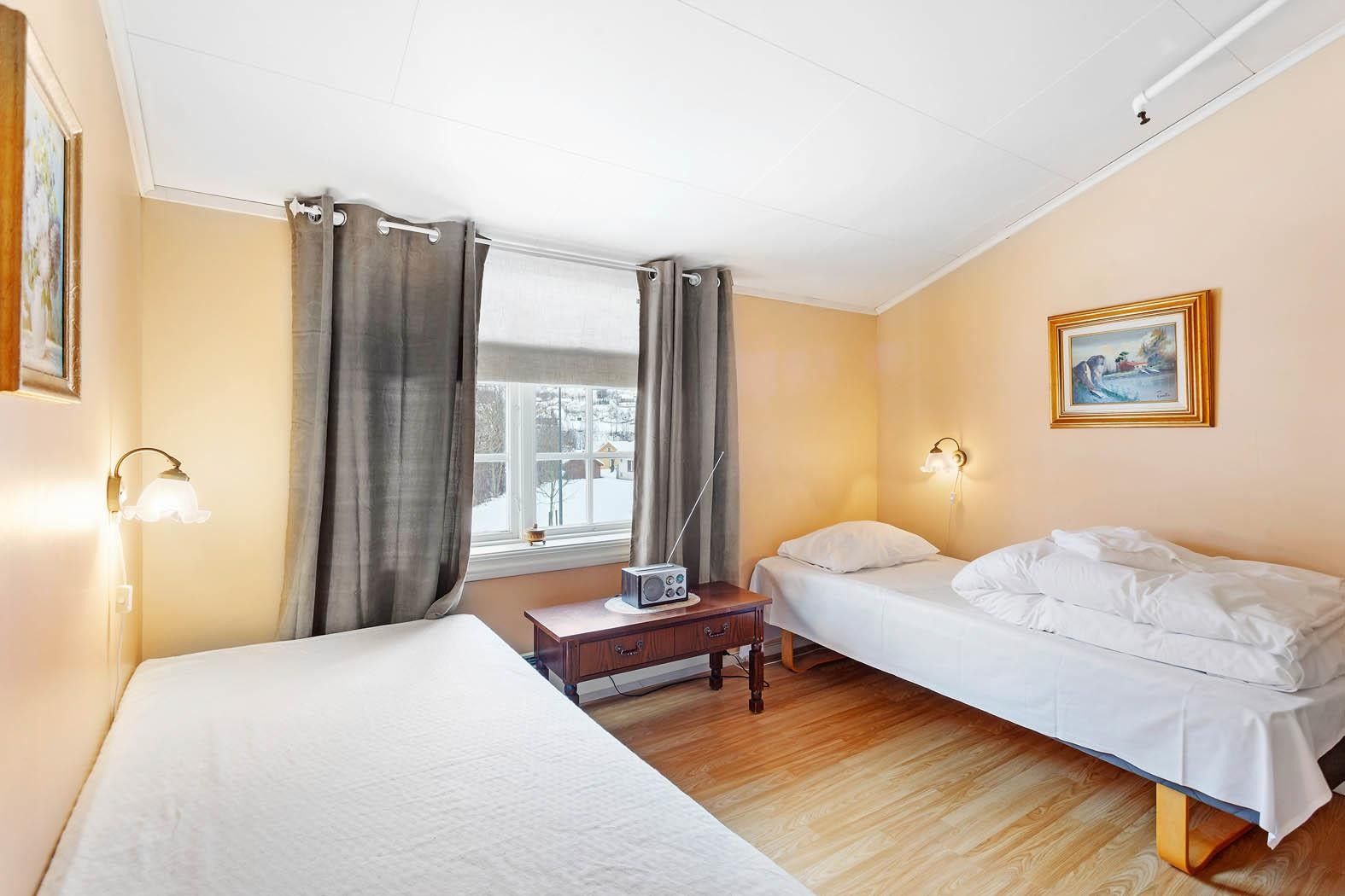 Bright twin bedroom with village view at Jaunsen Guesthouse in Hardanger.
