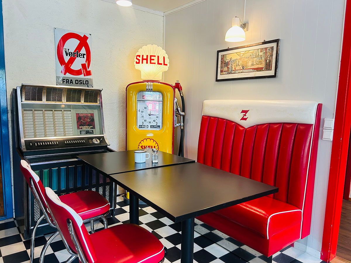 Kaféområde i retrostil på Z-Museum, med sitteplass, fargerike stoler og nostalgisk interiør