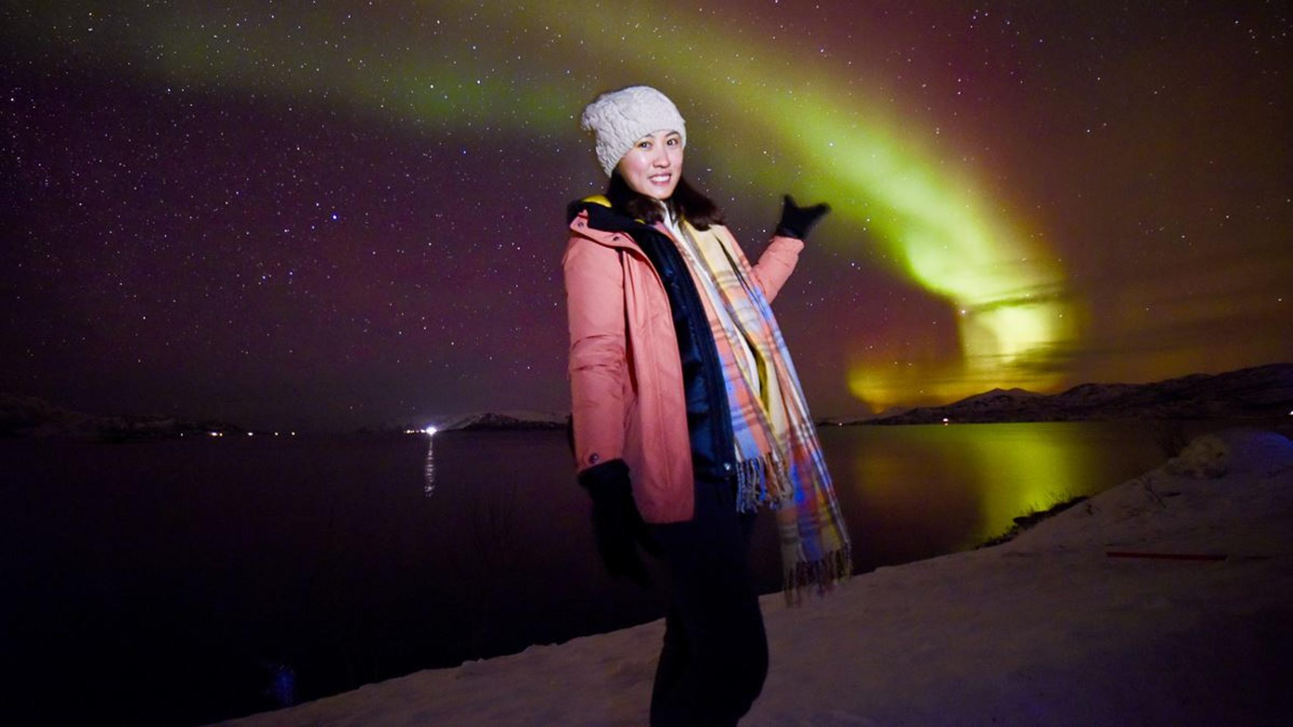 A guest standing under the northern lights