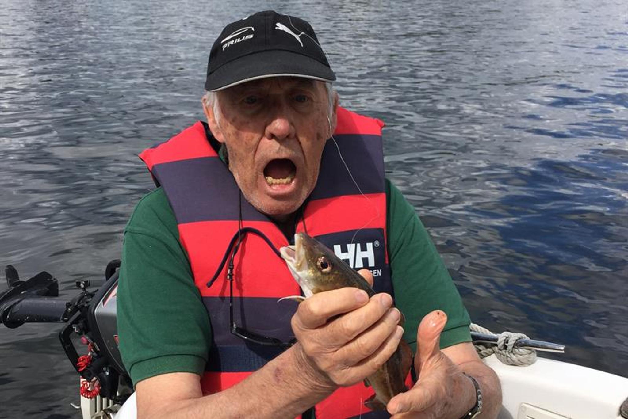 man on boat with fish in hand