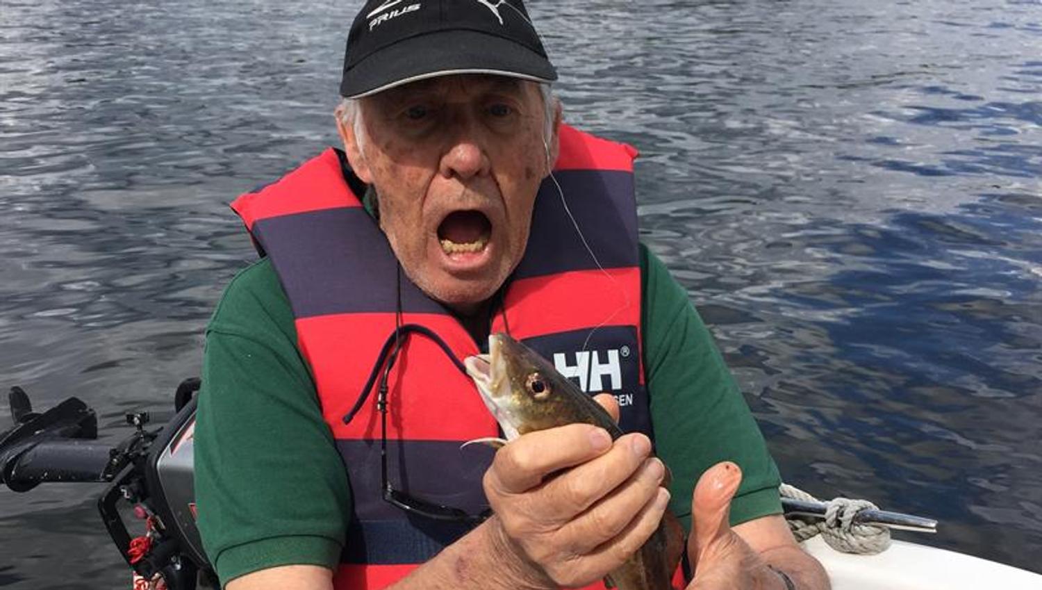 man on boat with fish in hand