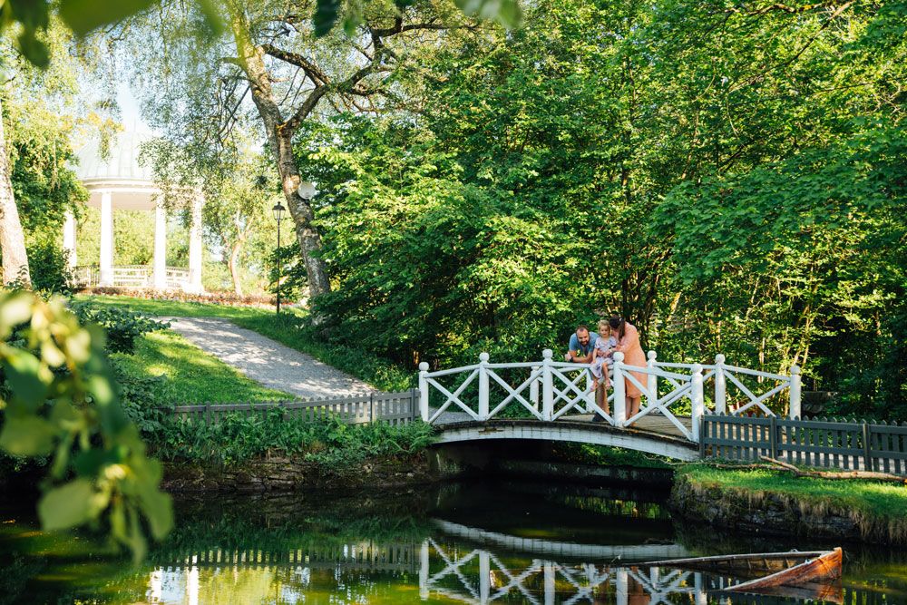 family standing on a bridge over the duck pond in Brekkeparken in Skien