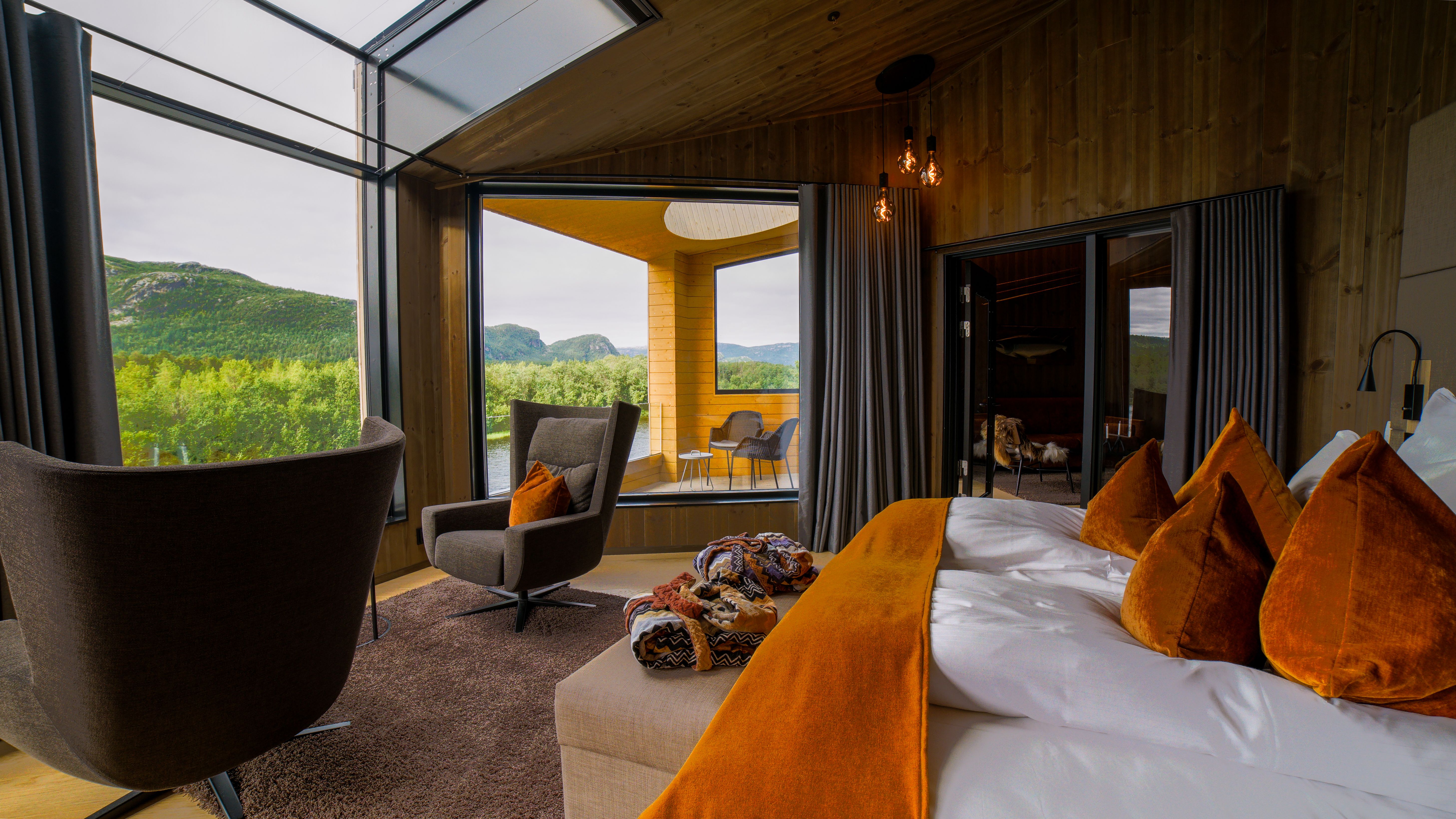 Stylish hotel room with modern furnishings and views of lush green hills.