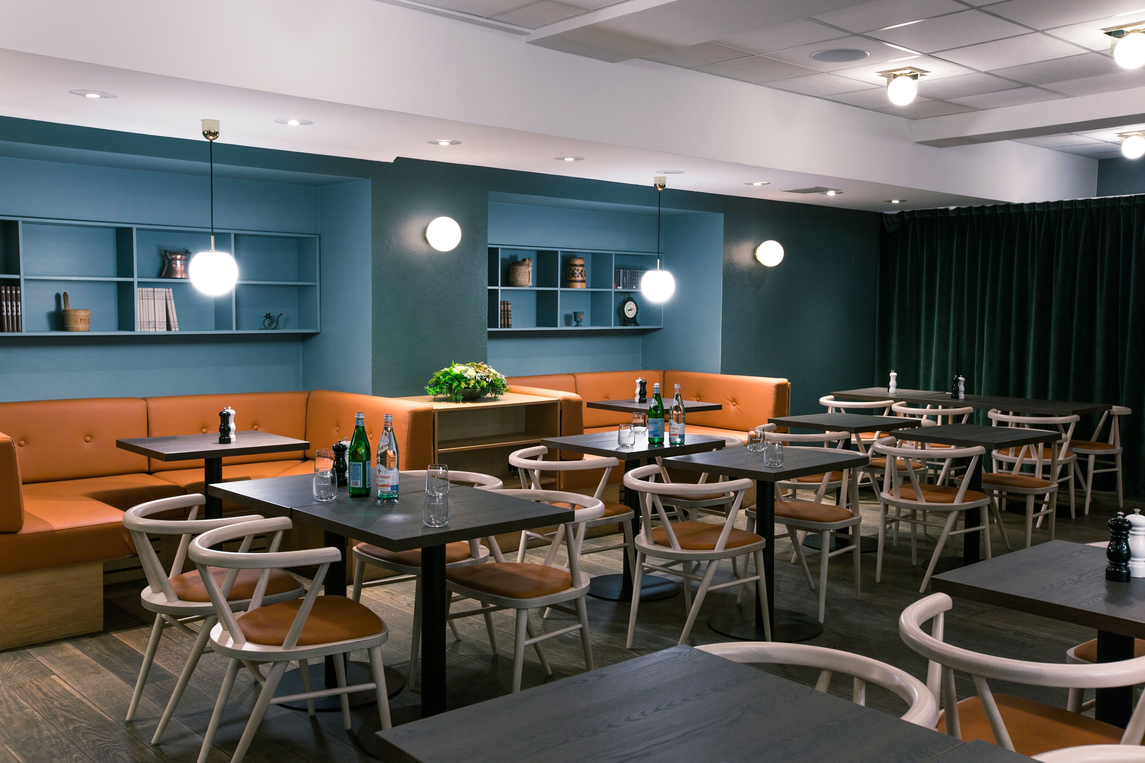 Interior with table, chairs and seating sections, blue walls.