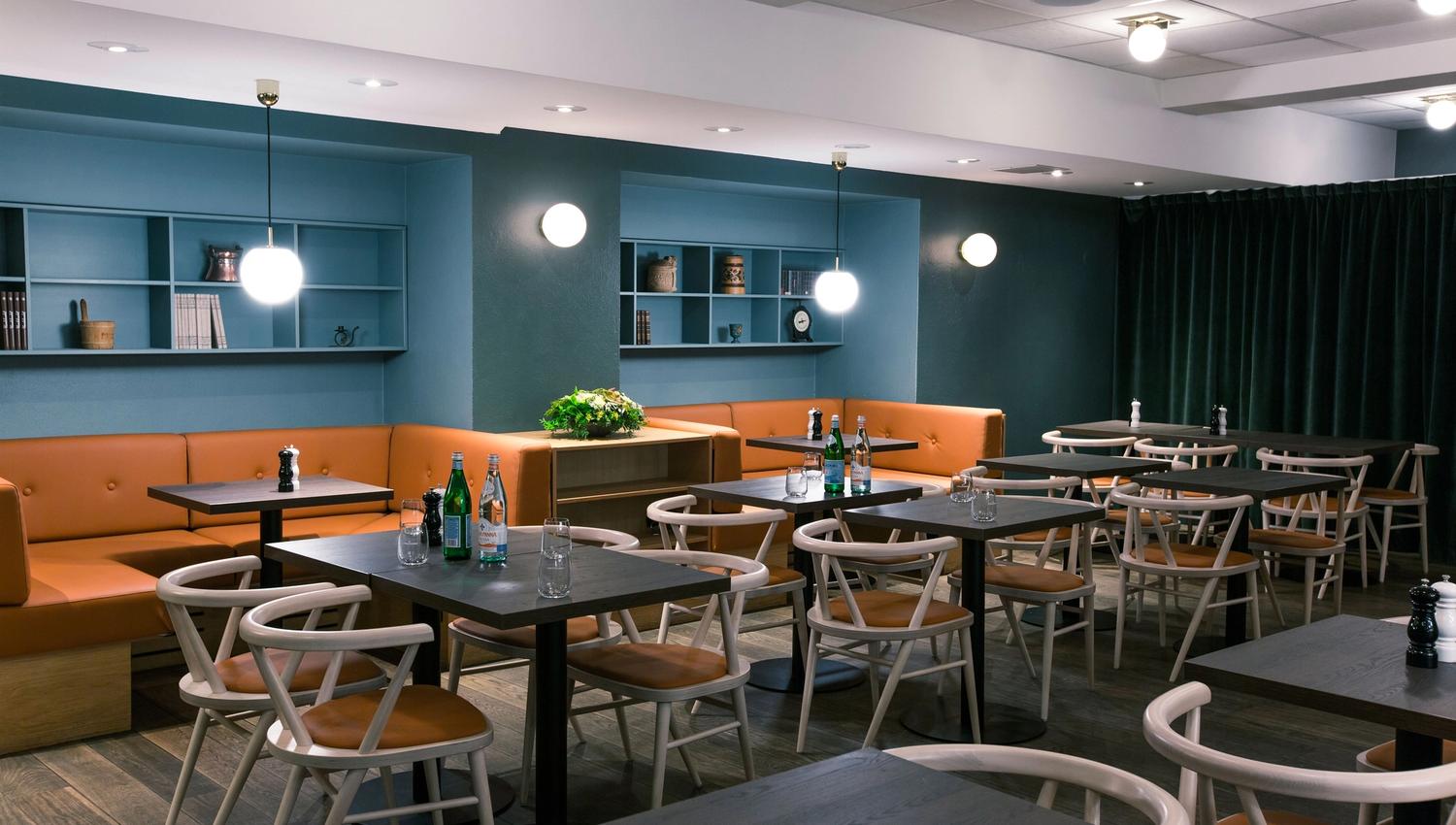 Interior with table, chairs and seating sections, blue walls.
