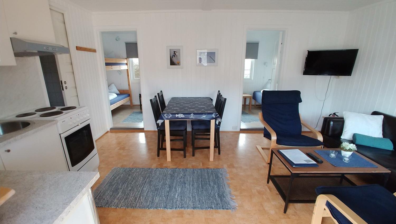 Living room with sofa, chairs, table, kitchen table and kitchen chairs, kitchen nook and view to the bedrooms