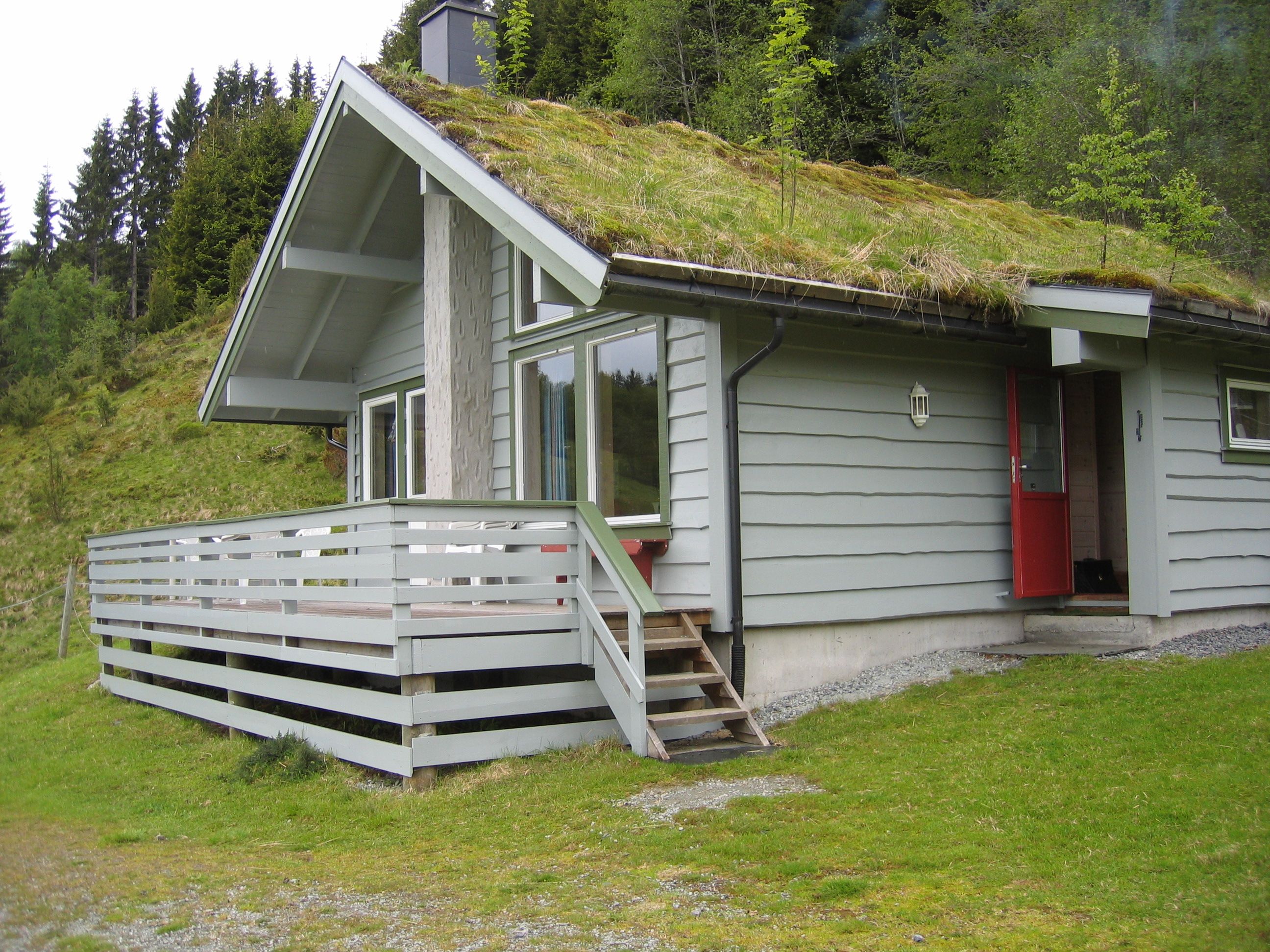 Traditional Norwegian cabin with a turf roof and spacious terrace, surrounded by stunning nature.