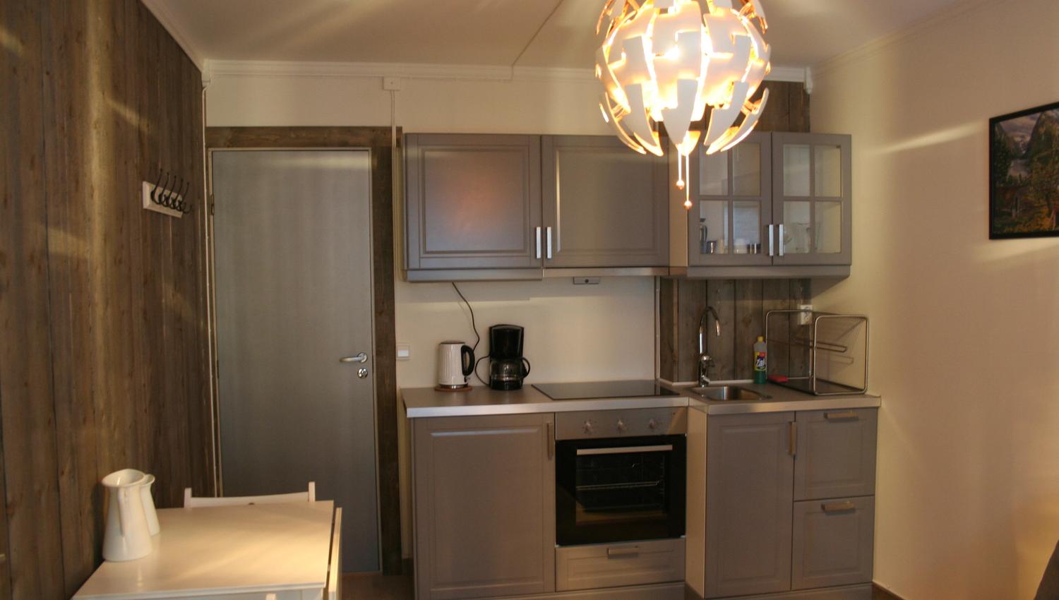 Apartment at Kvamseter Lodge featuring a fully equipped kitchen and small dining area.