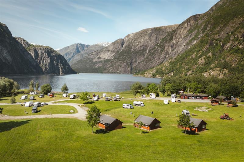 Sæbø camping seen from the main road, with the lake and mountains in the background.