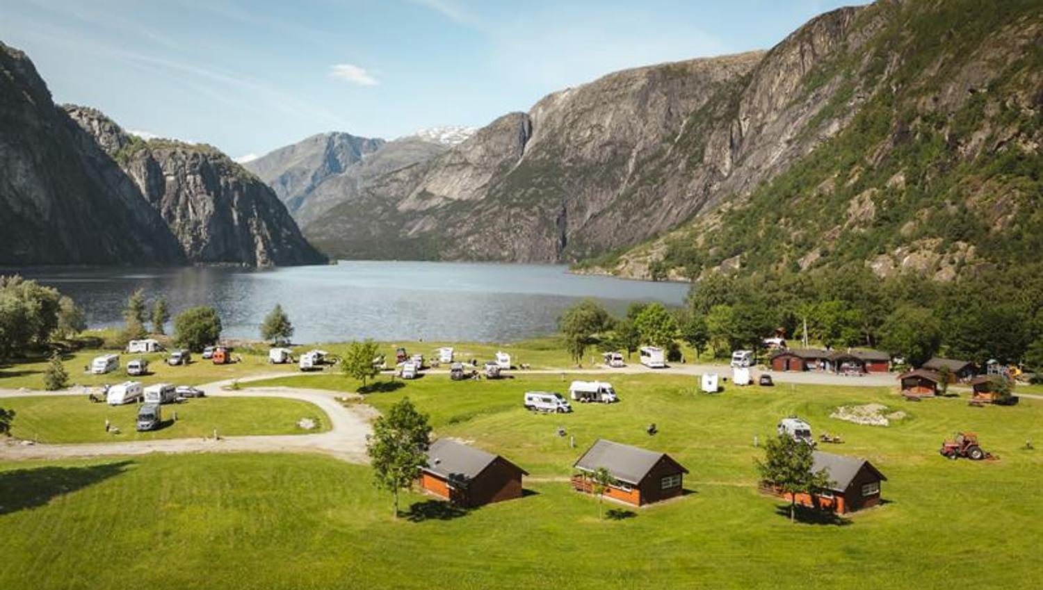 Sæbø camping seen from the main road, with the lake and mountains in the background.