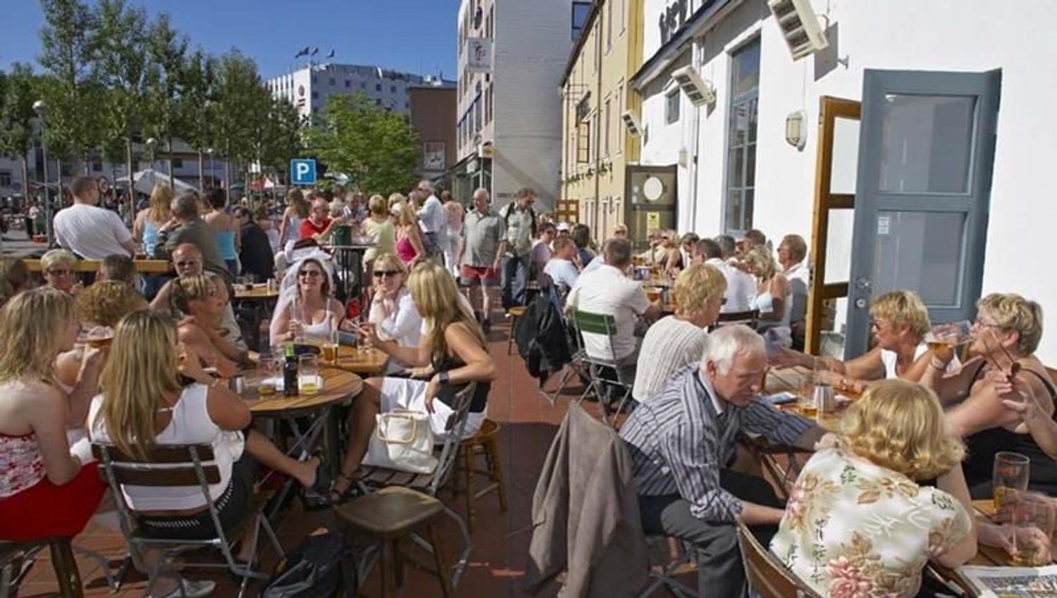 People enjoying food and drinks at Skarven in the sunshine.