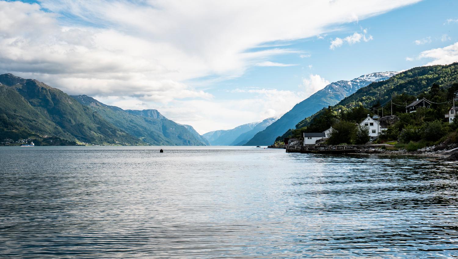Sjarmerande fjordlandskap med idylliske hus langs Hardangerfjorden.