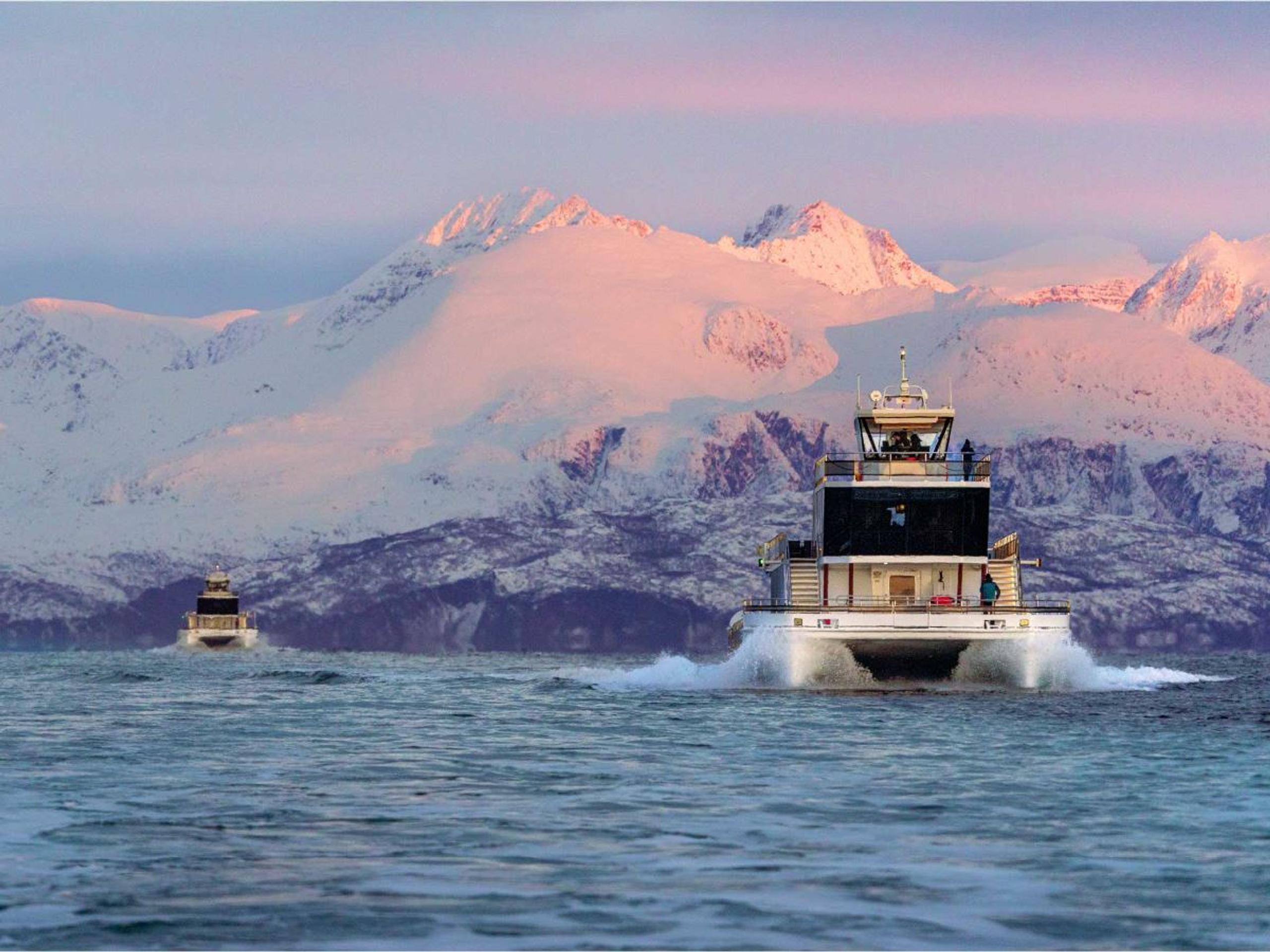 Boat in the sea with the Arctic landscape in the background