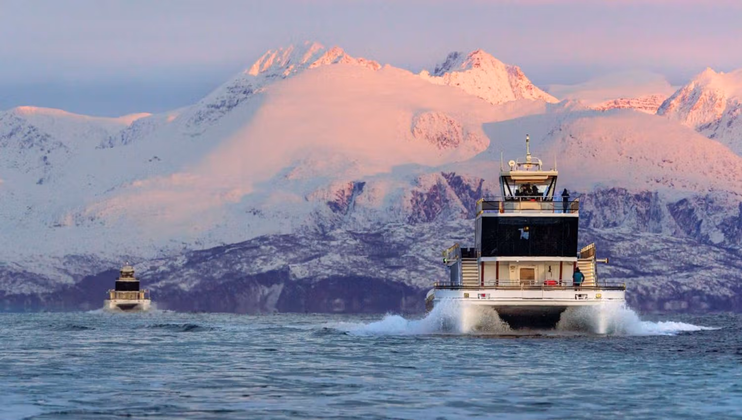 Boat in the sea with the Arctic landscape in the background
