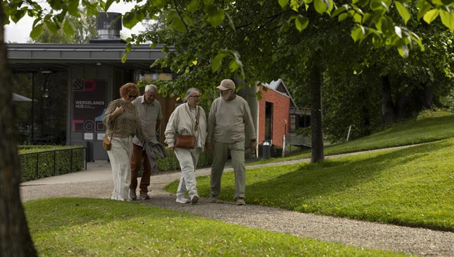 Visitors exploring a heritage site with historic buildings and green lawns.