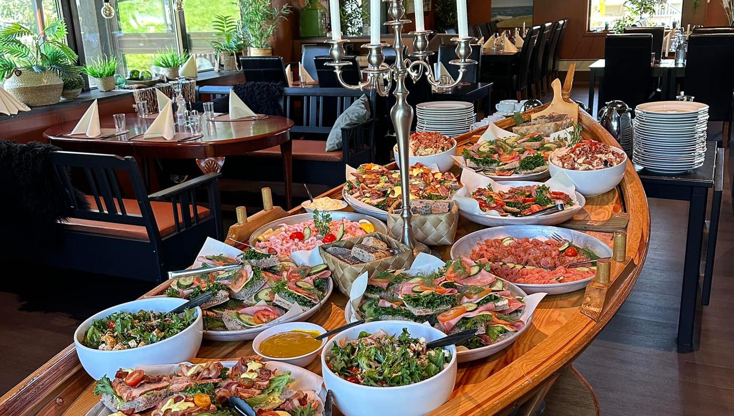 Ein innbydande sjømatbuffet servert på ein tradisjonell trebåt i Gjøa Sjømat, Rosendal. Eit utval av fersk fisk, reker og lokale delikatesser.