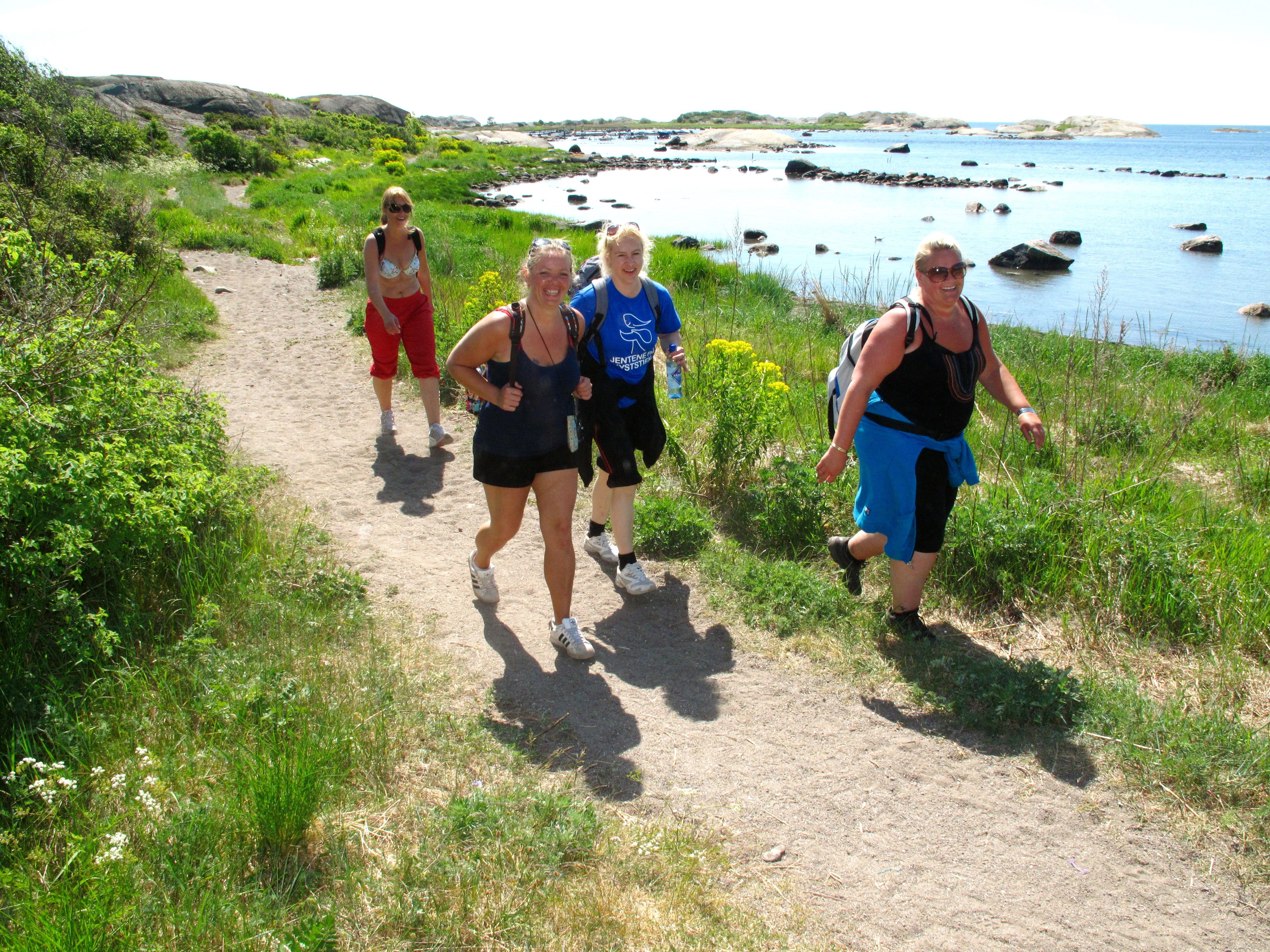 Folk går tur på kyststi